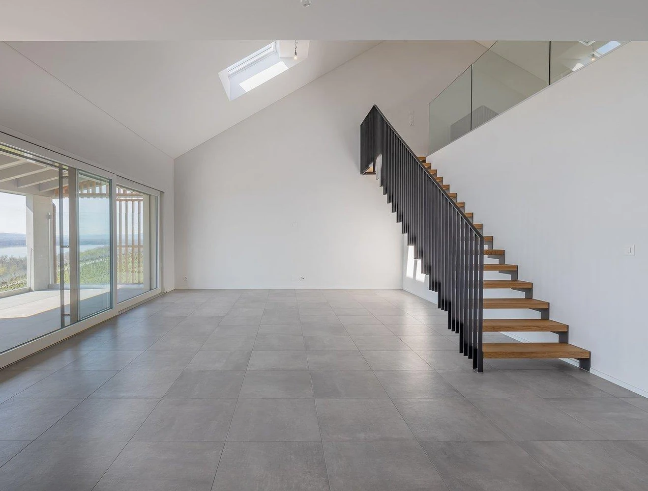 Offener Wohnraum mit Treppe und Seeblick
