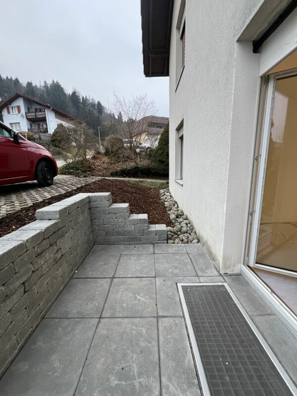 Außenbereich mit kleiner gepflasterter Terrasse