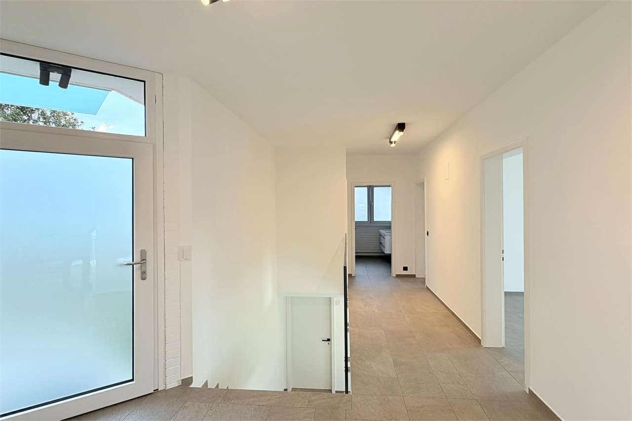 Heller Flur mit Treppe und Eingangstür