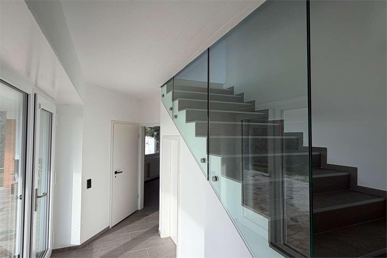 Moderner Eingangsbereich mit Treppe und Glasgeländer