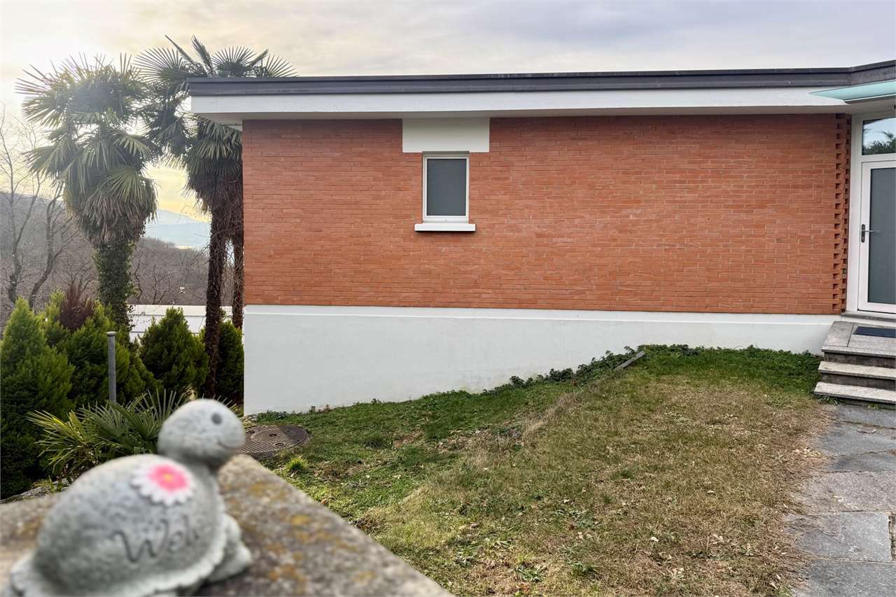 Außenansicht eines eingeschossigen Hauses mit Garten