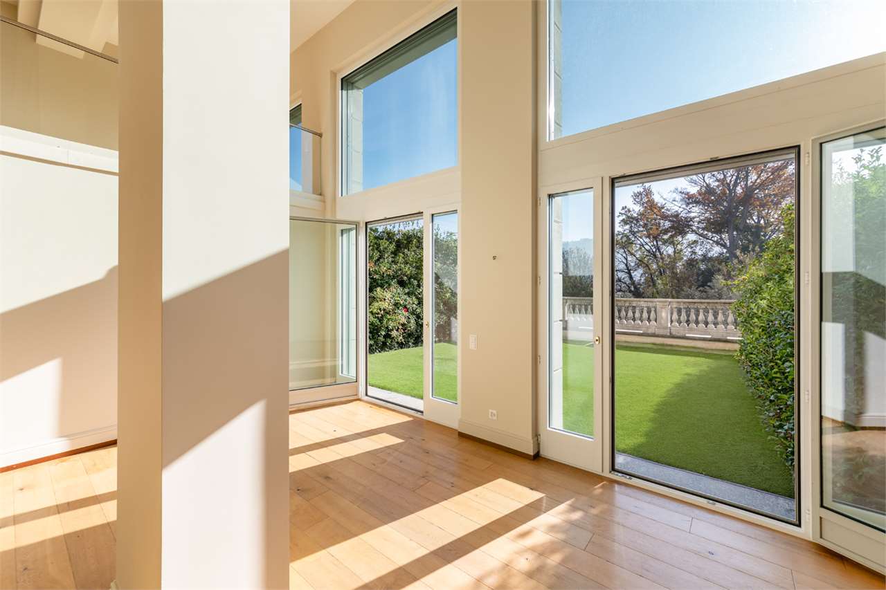 Heller Wohnraum mit bodentiefen Fenstern und Gartenblick