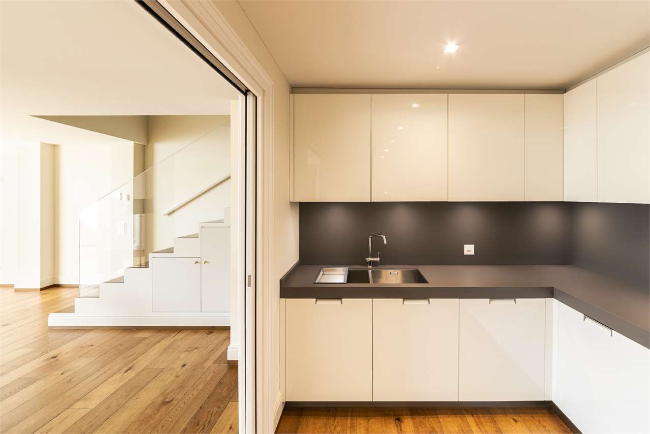 Moderne Einbauküche mit Treppe im Hintergrund