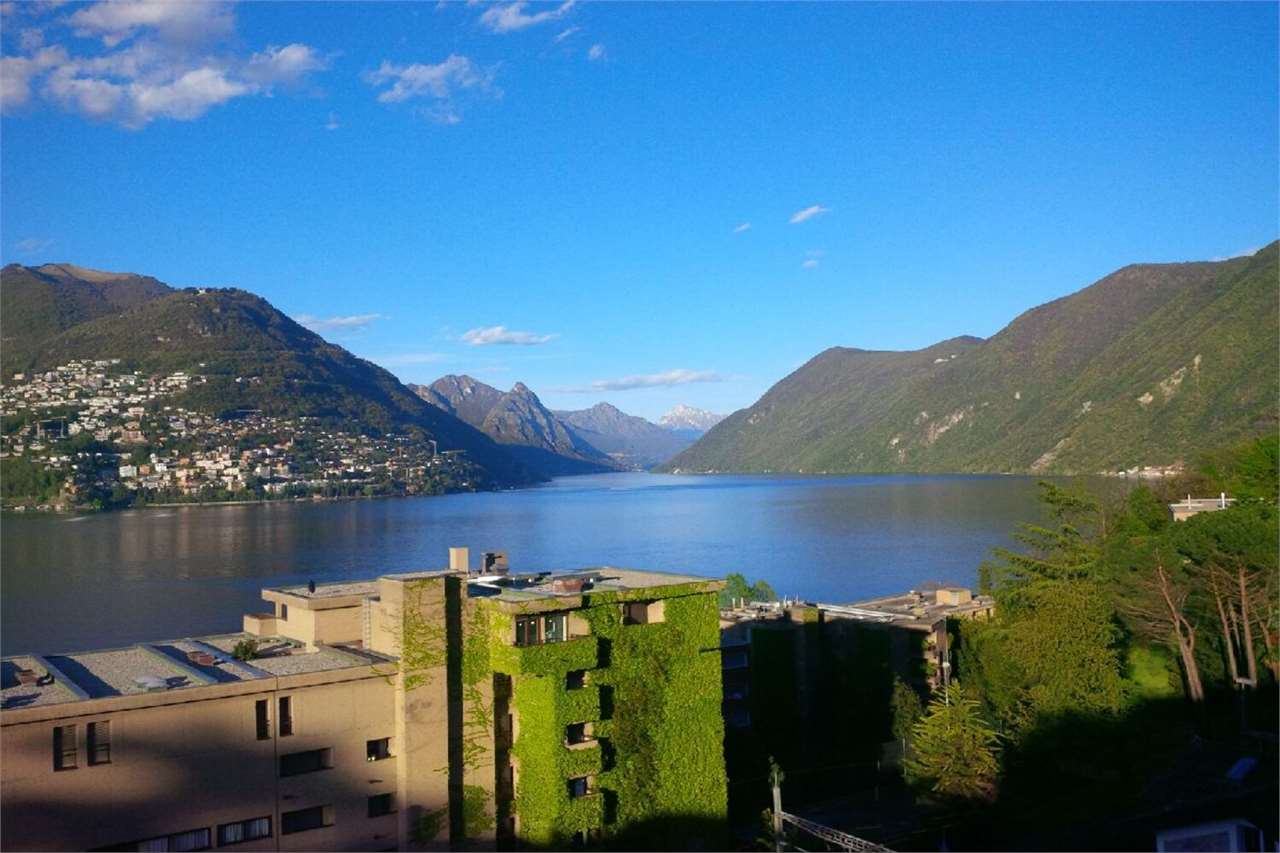 Seeblick mit Bergen und Wohngebäuden