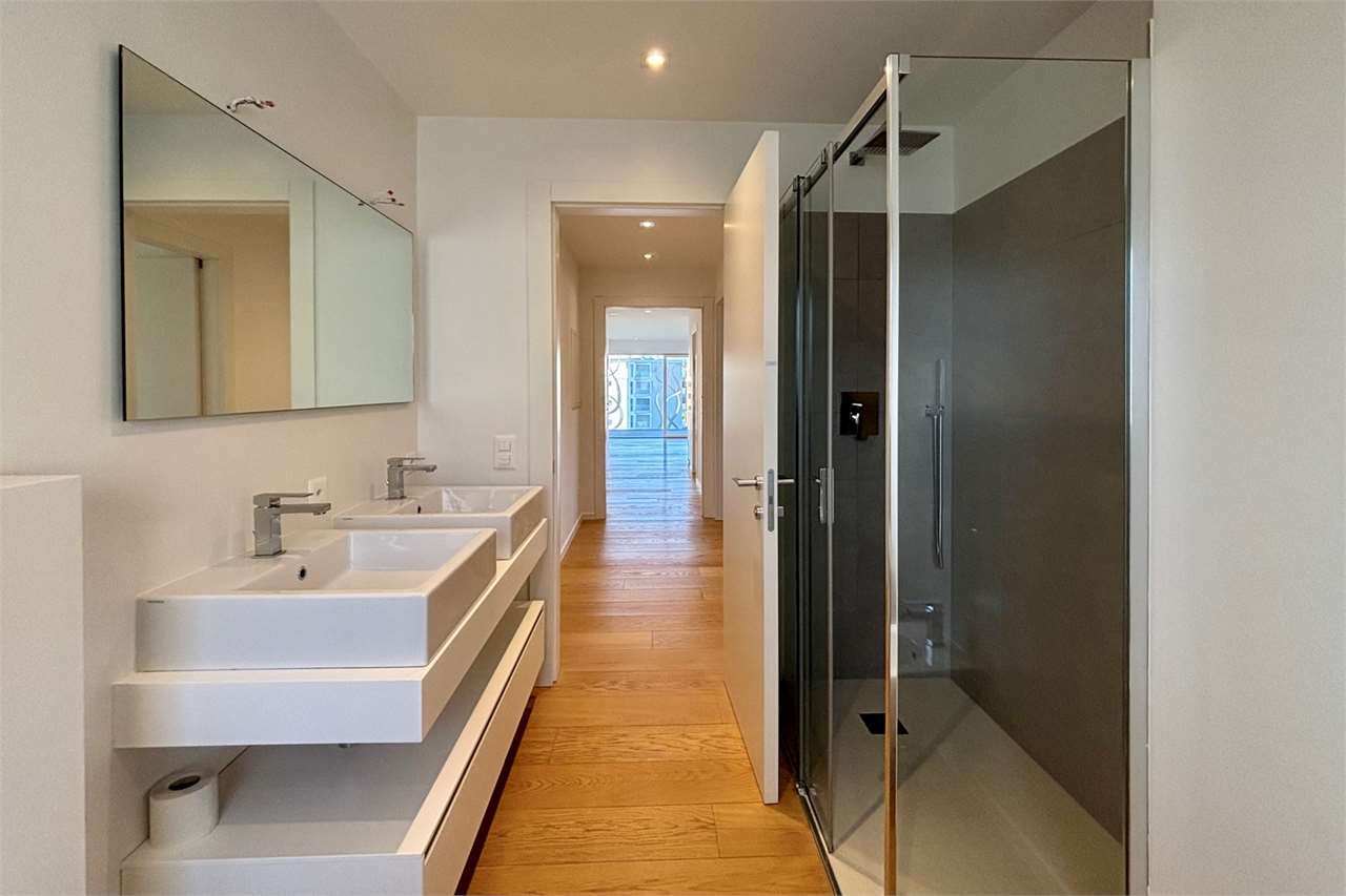 Modernes Badezimmer mit Doppelwaschbecken und Glasdusche