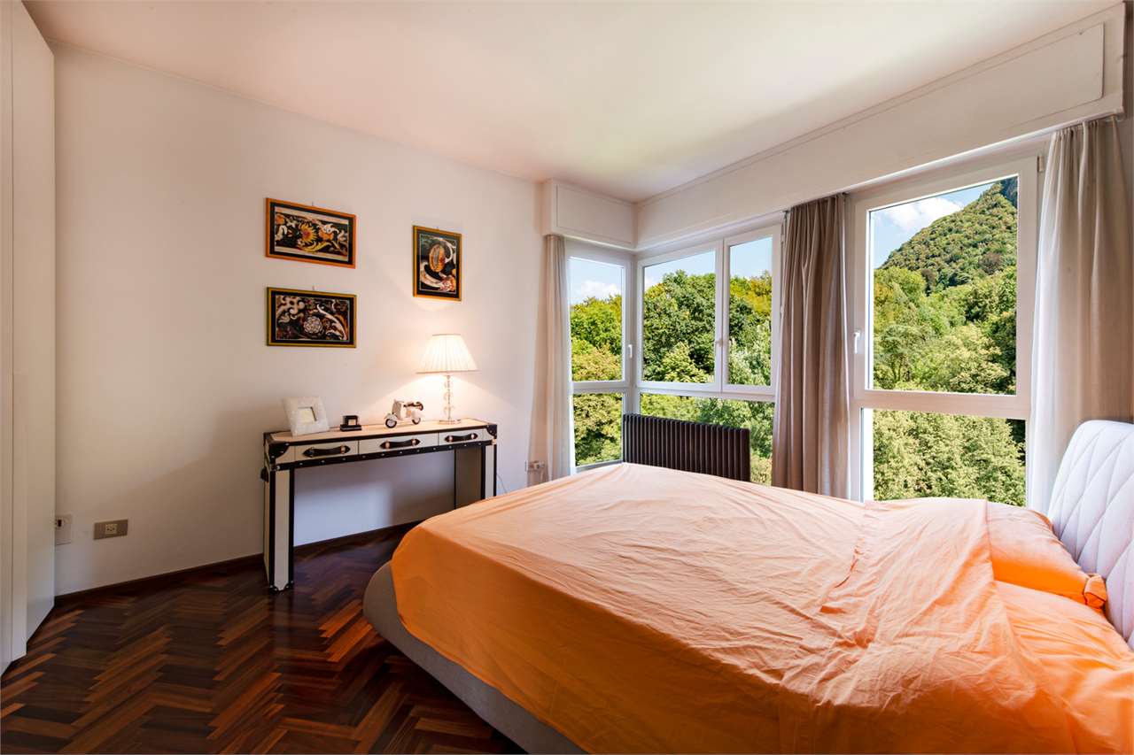 Schlafzimmer mit großem Panoramafenster und Bergblick