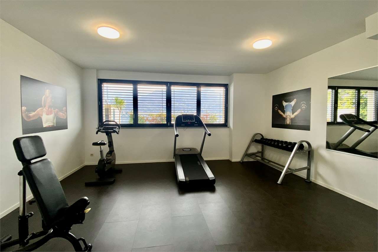 Fitnessraum mit Laufband und Hantelbereich