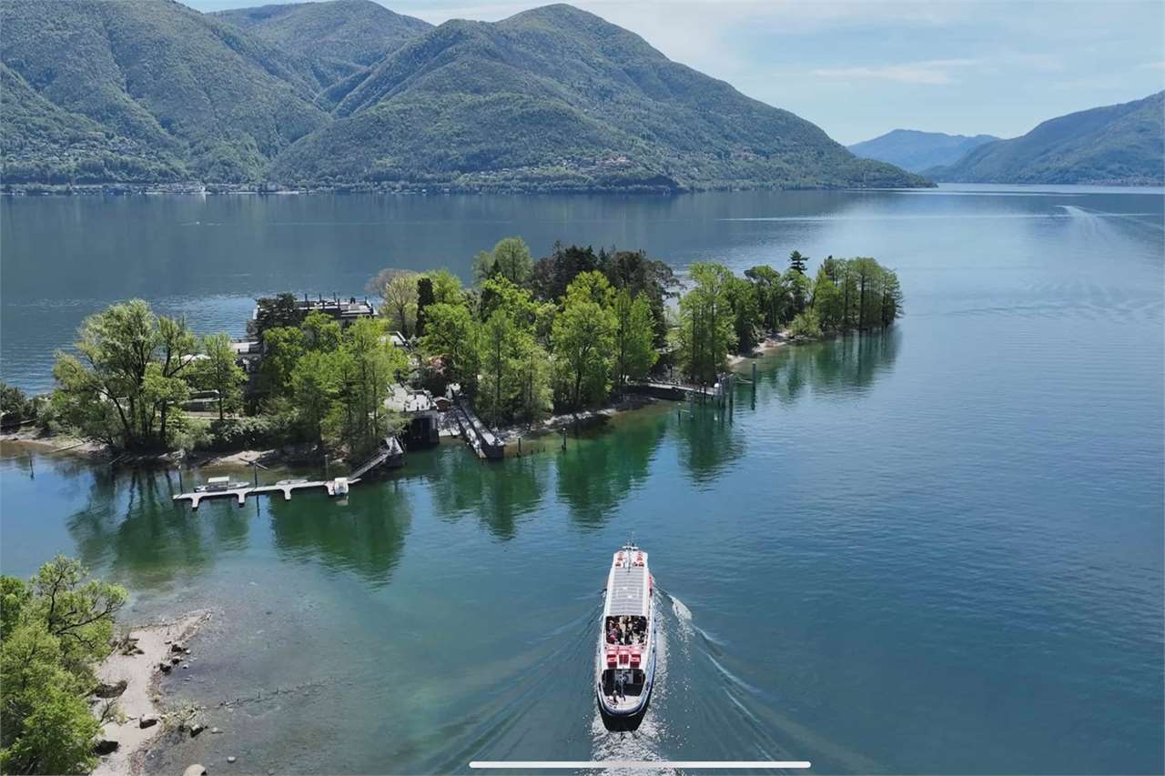 Luftaufnahme einer Insel im See mit Bergen im Hintergrund