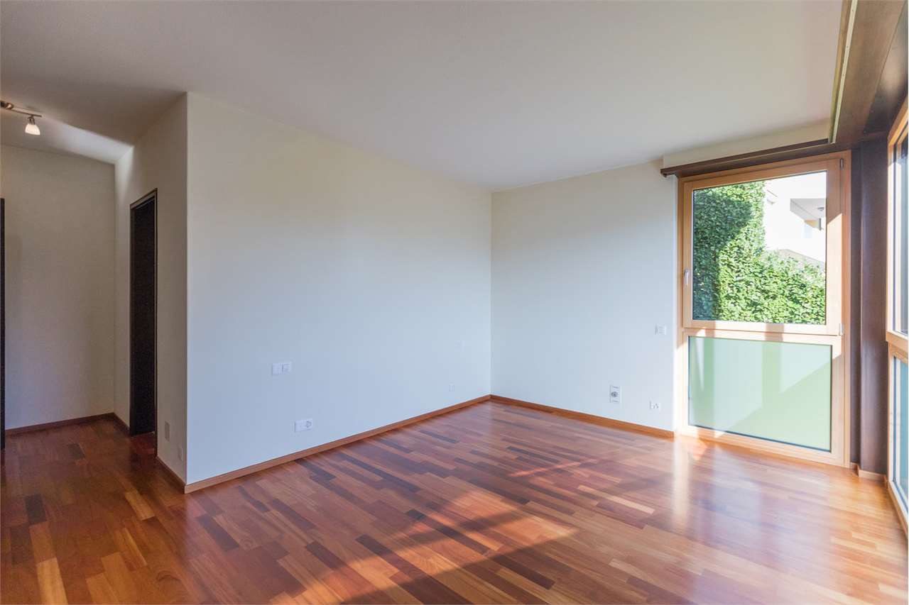 Leerer Wohnraum mit Holzparkett und Fensterfront