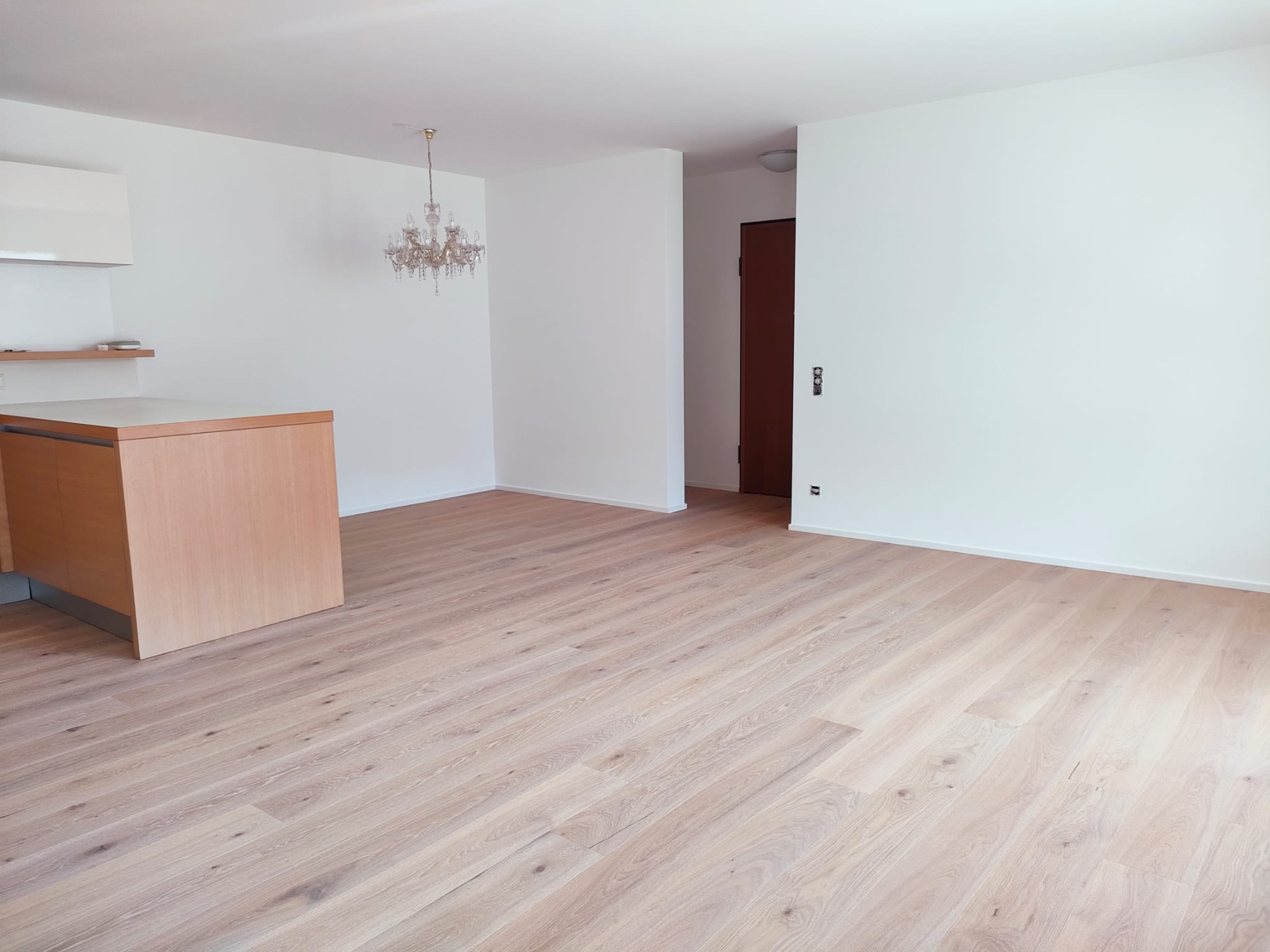 Leerer Wohnbereich mit Holzboden und Kücheninsel