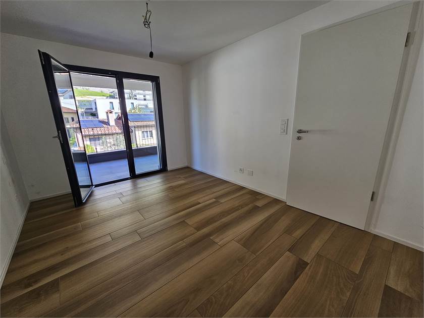 Leerer Wohnraum mit Balkonzugang