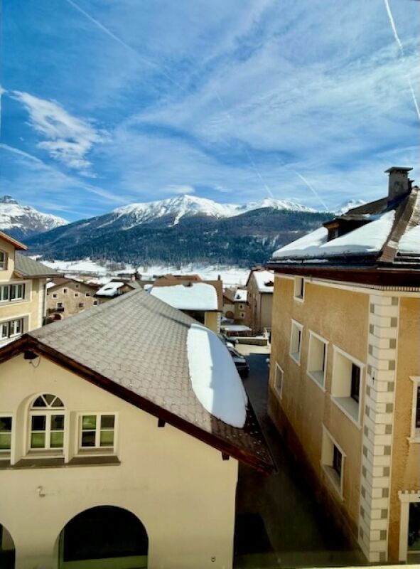 Schneebedeckte Alpenhäuser mit Bergpanorama