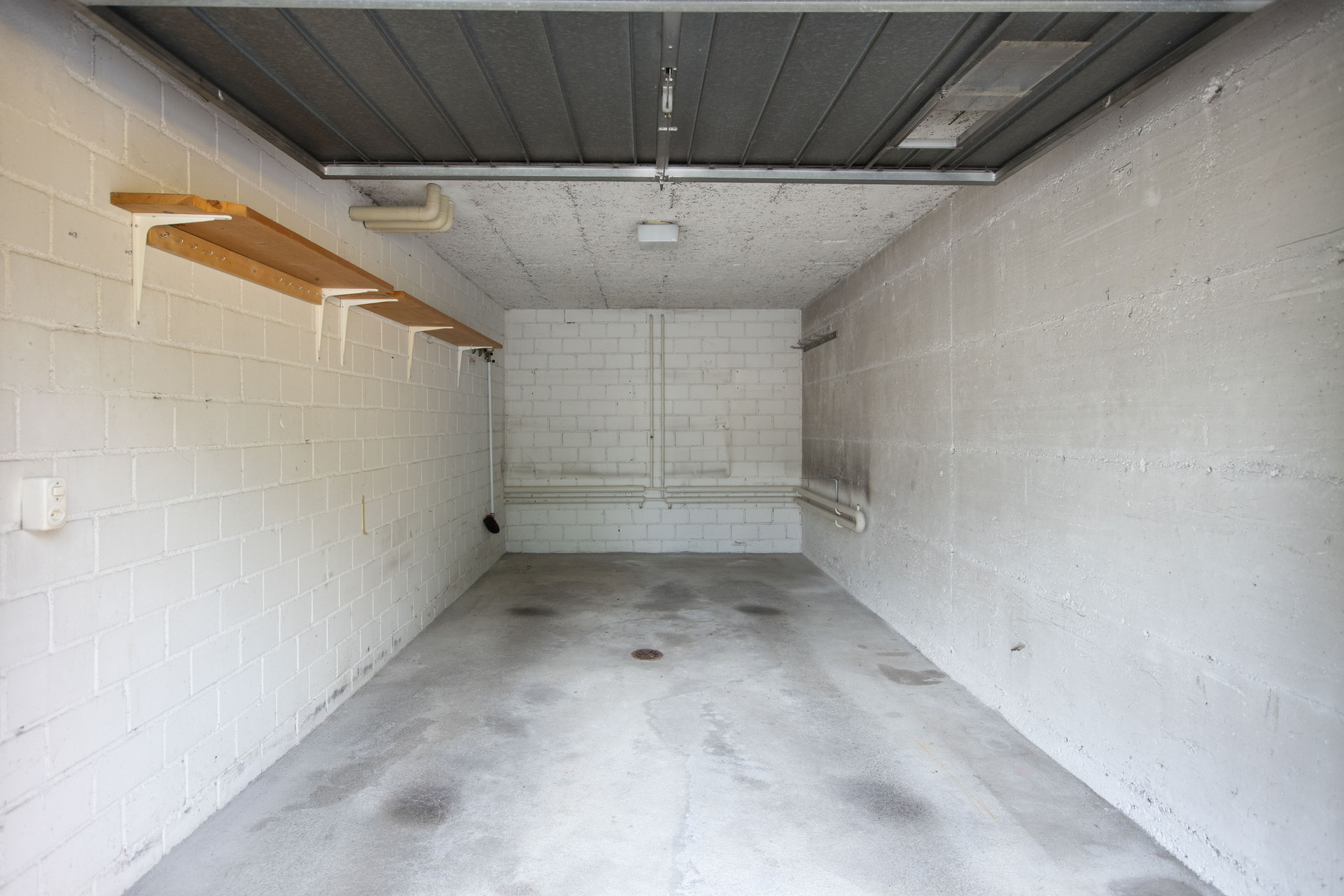 Garage mit Betonwänden und Regalen