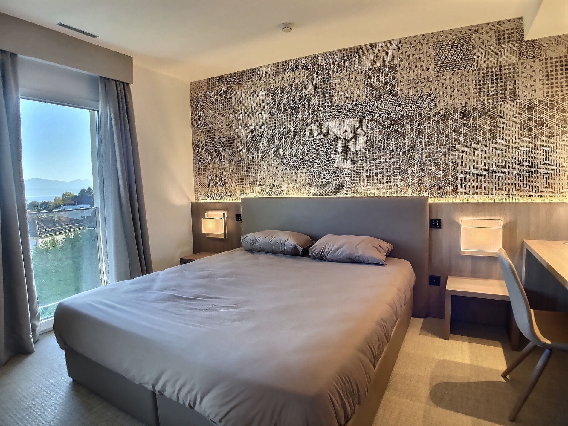 Modernes Schlafzimmer mit großem Fenster und Meerblick
