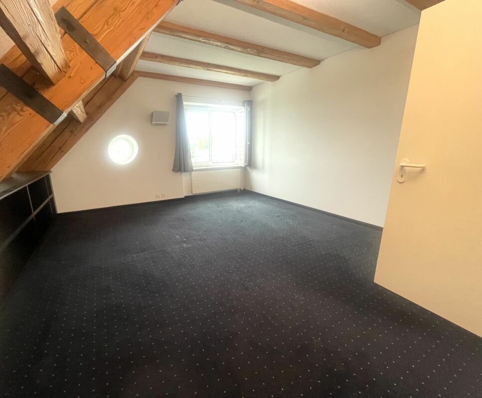 Dachgeschossraum mit sichtbaren Holzbalken