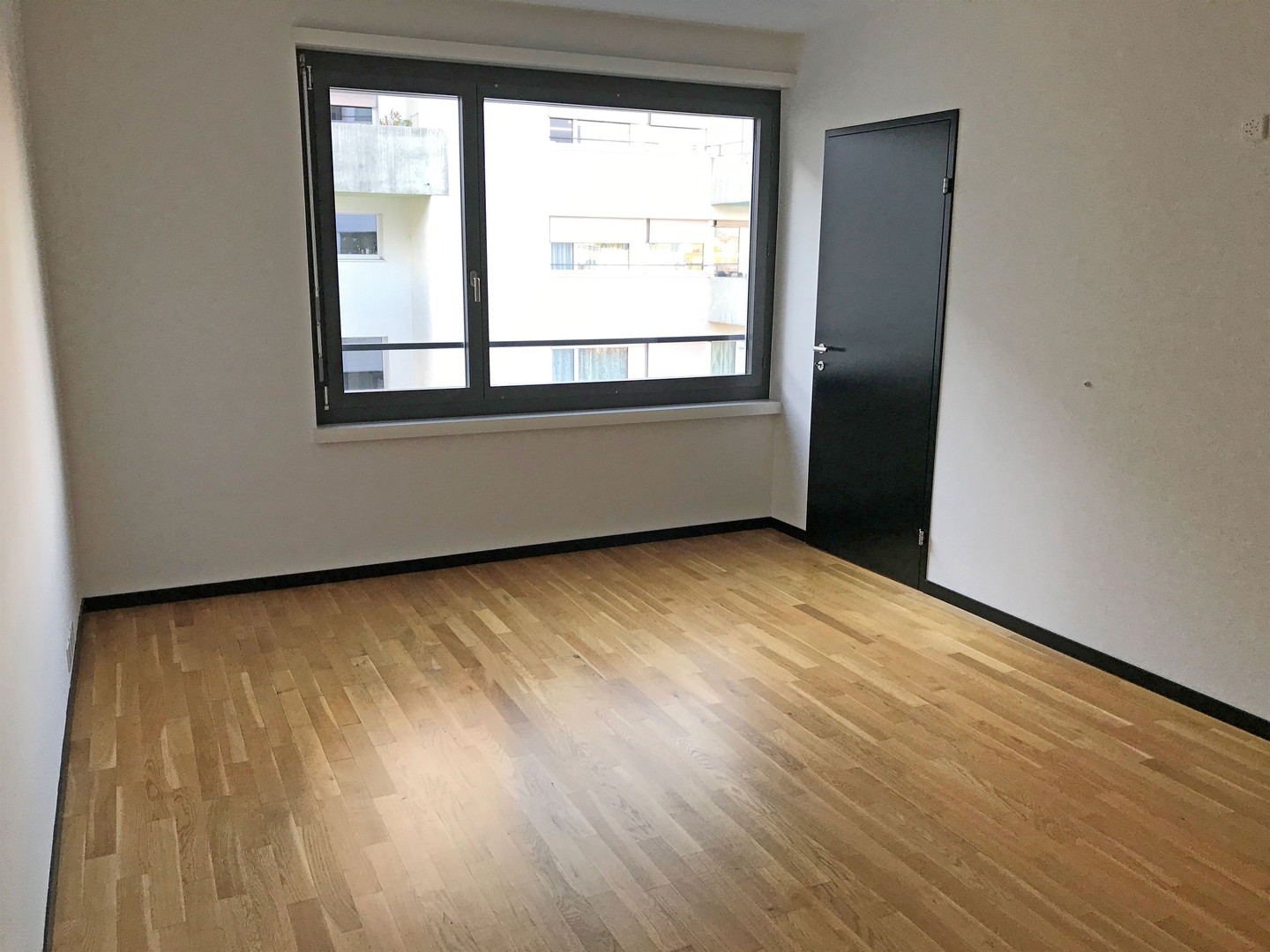 Leeres Zimmer mit Holzparkett und Fenster