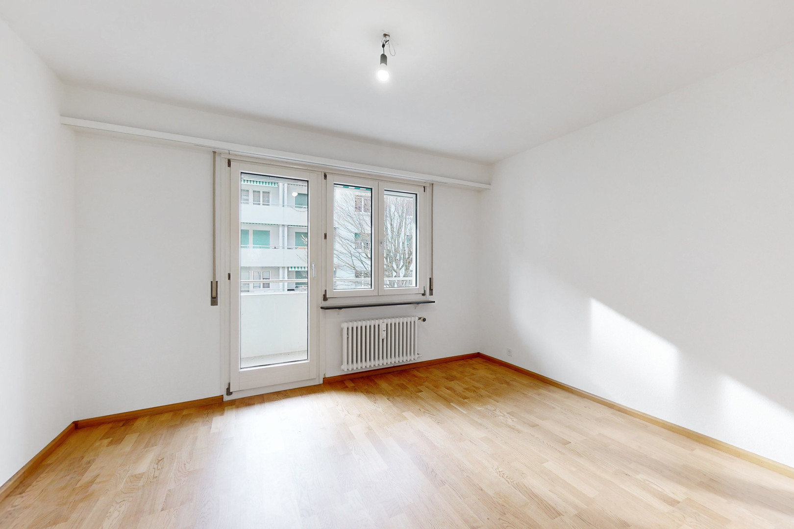Leerer, heller Wohnraum mit Balkon und Fenster