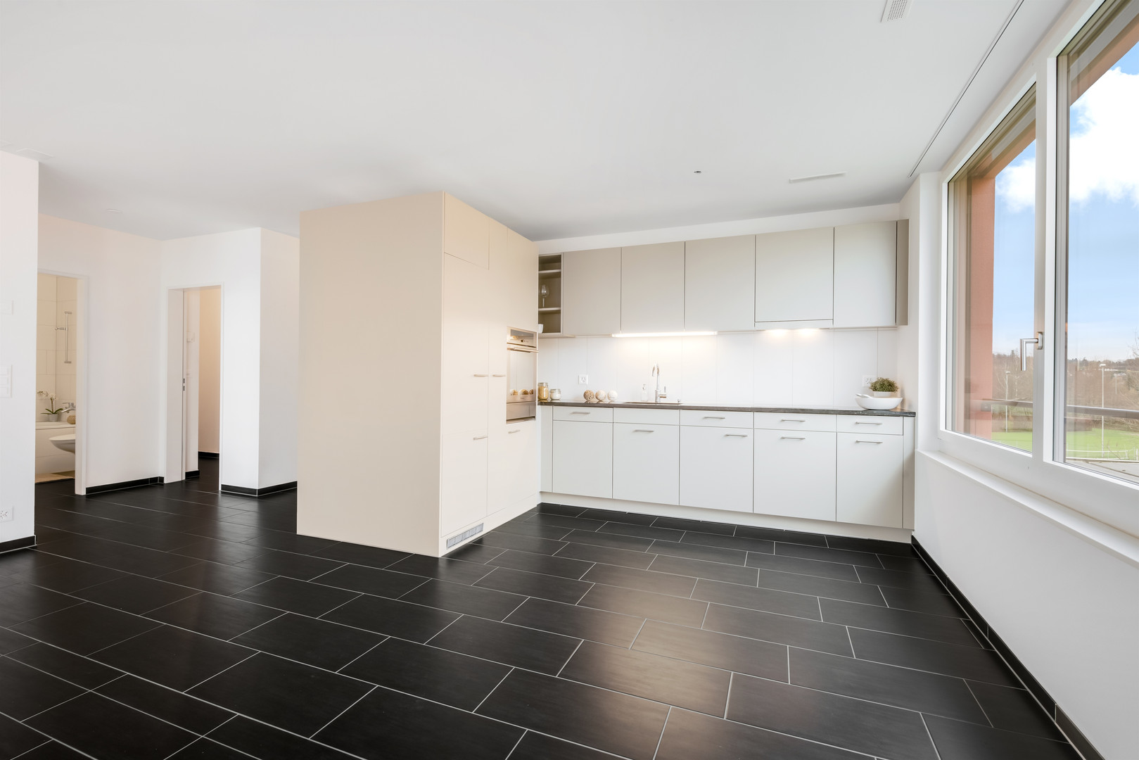 Offene, moderne Küche mit großem Fenster