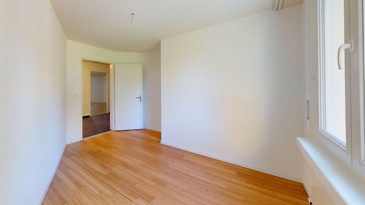 Leerer heller Raum mit Holzboden und Fenster