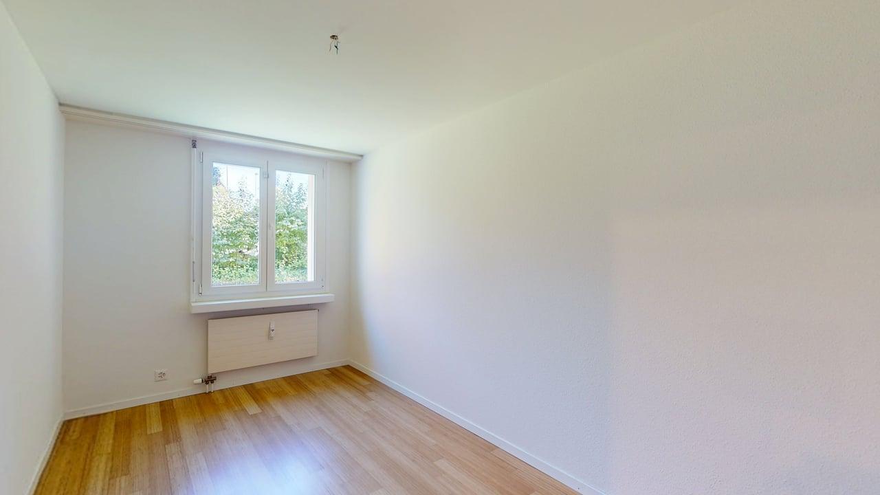 Leerer heller Raum mit Fenster und Holzfußboden