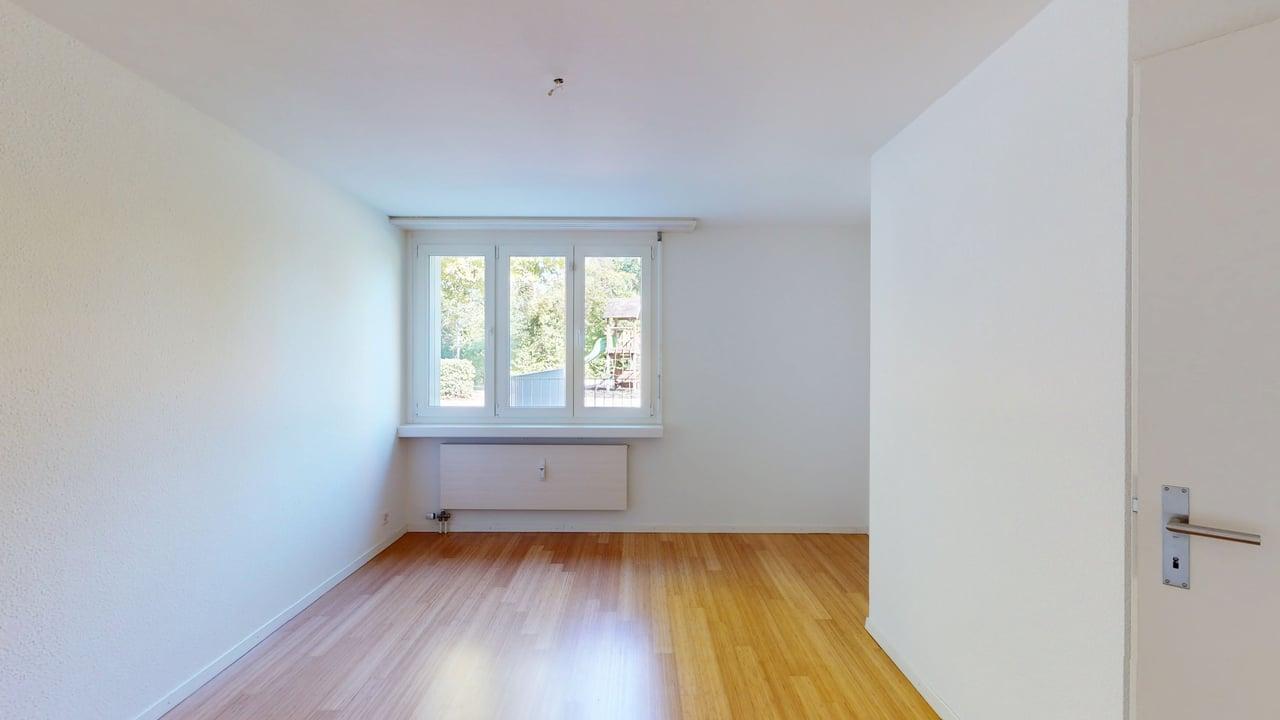 Helles, leeres Zimmer mit Fenster und Heizkörper