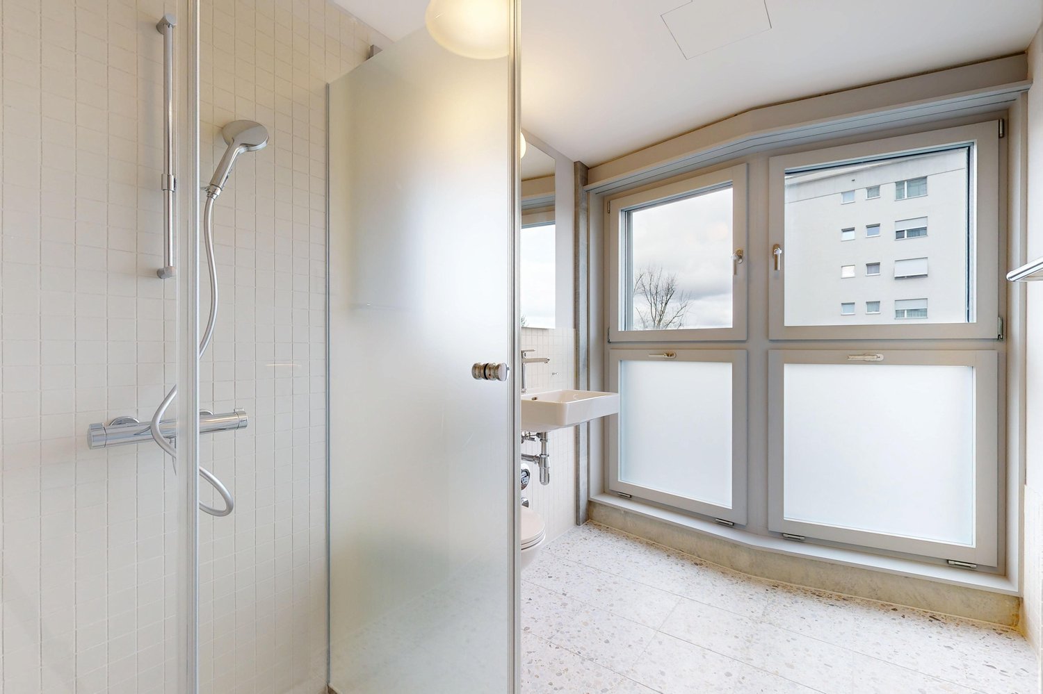 Helles Badezimmer mit Dusche und Fensterfront
