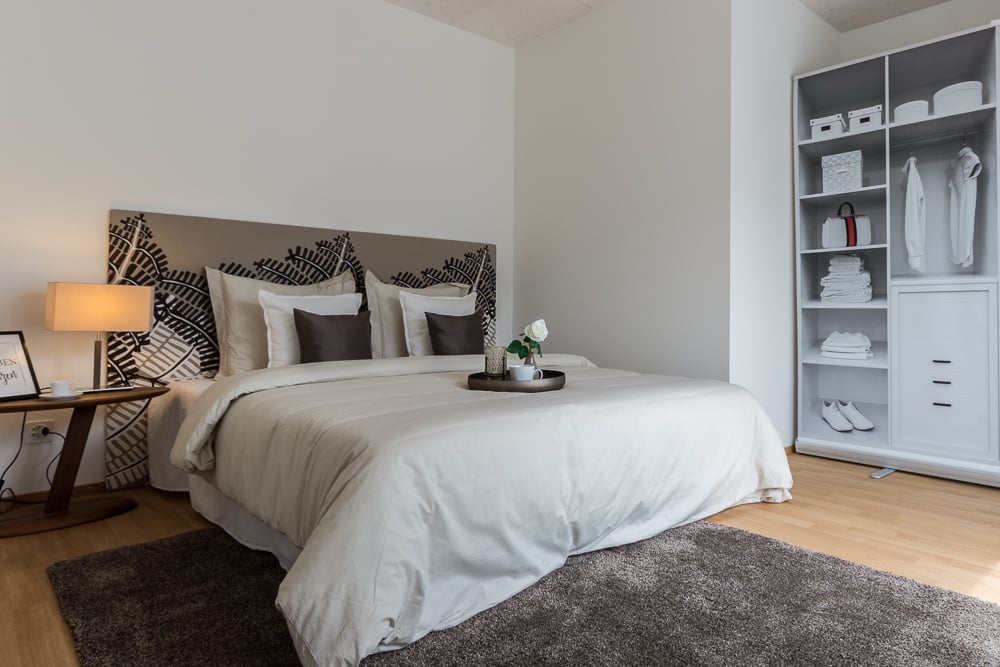 Helles Schlafzimmer mit Bett und offenem Kleiderschrank