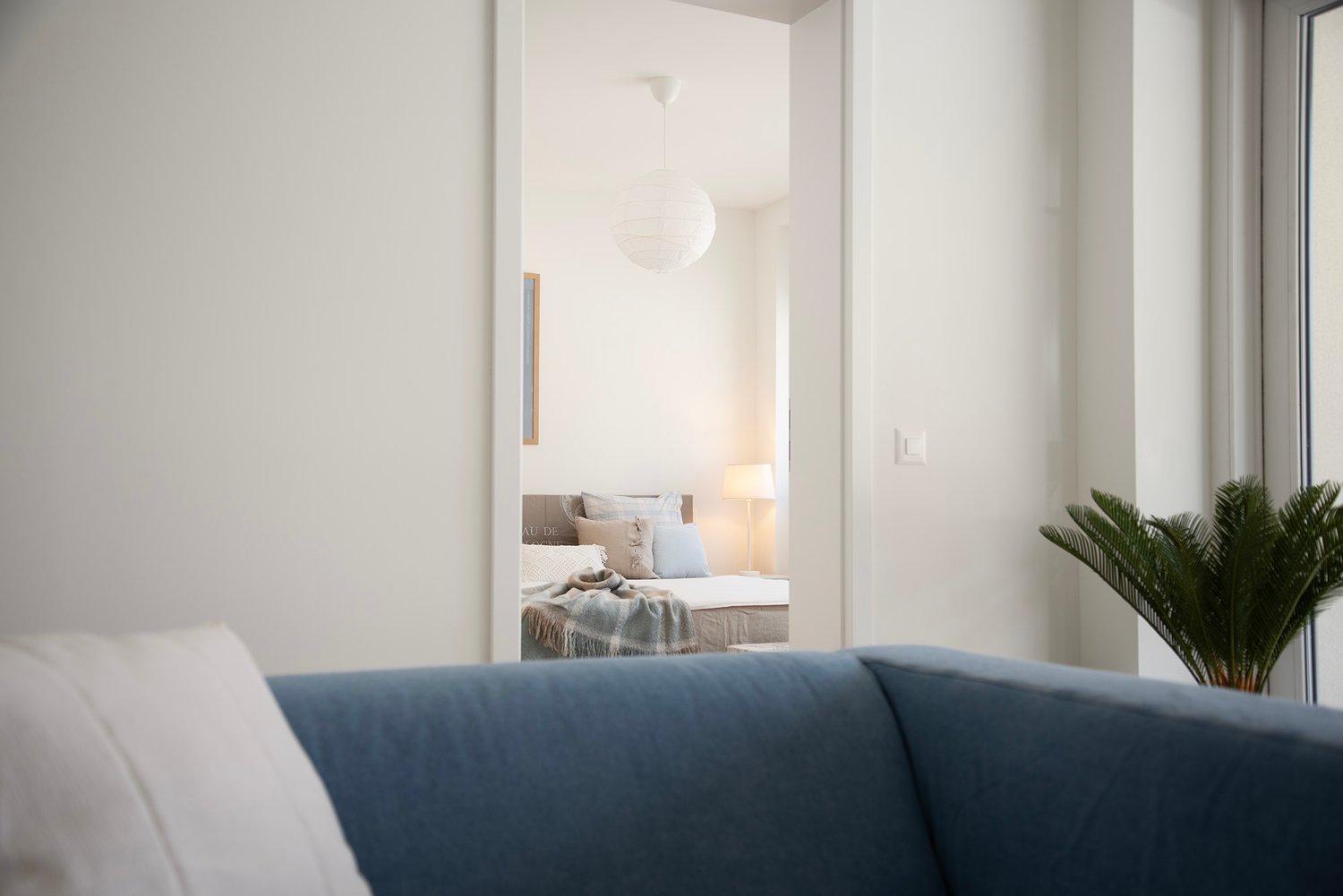Heller Wohnraum mit Blick in ein Schlafzimmer