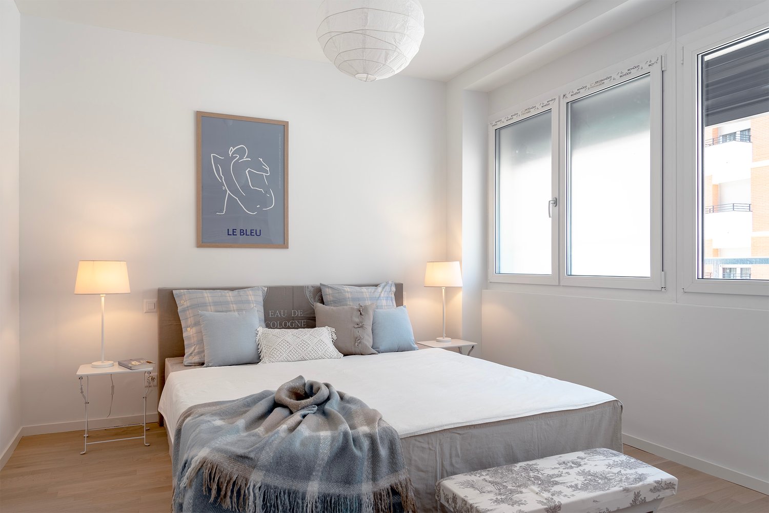 Helles Schlafzimmer mit zwei Fenstern und Doppelbett