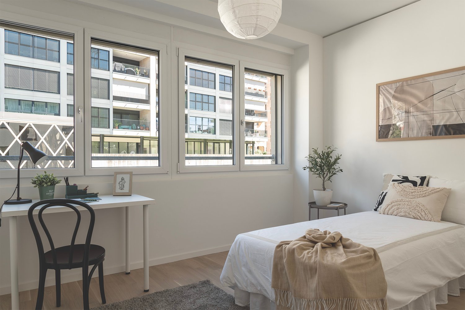 Helles Schlafzimmer mit Schreibtisch am Fenster
