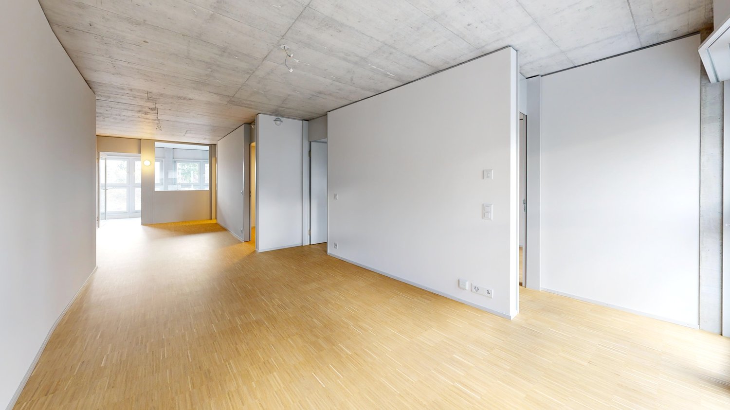 Offener, leerer Wohnraum mit Beton-Decke