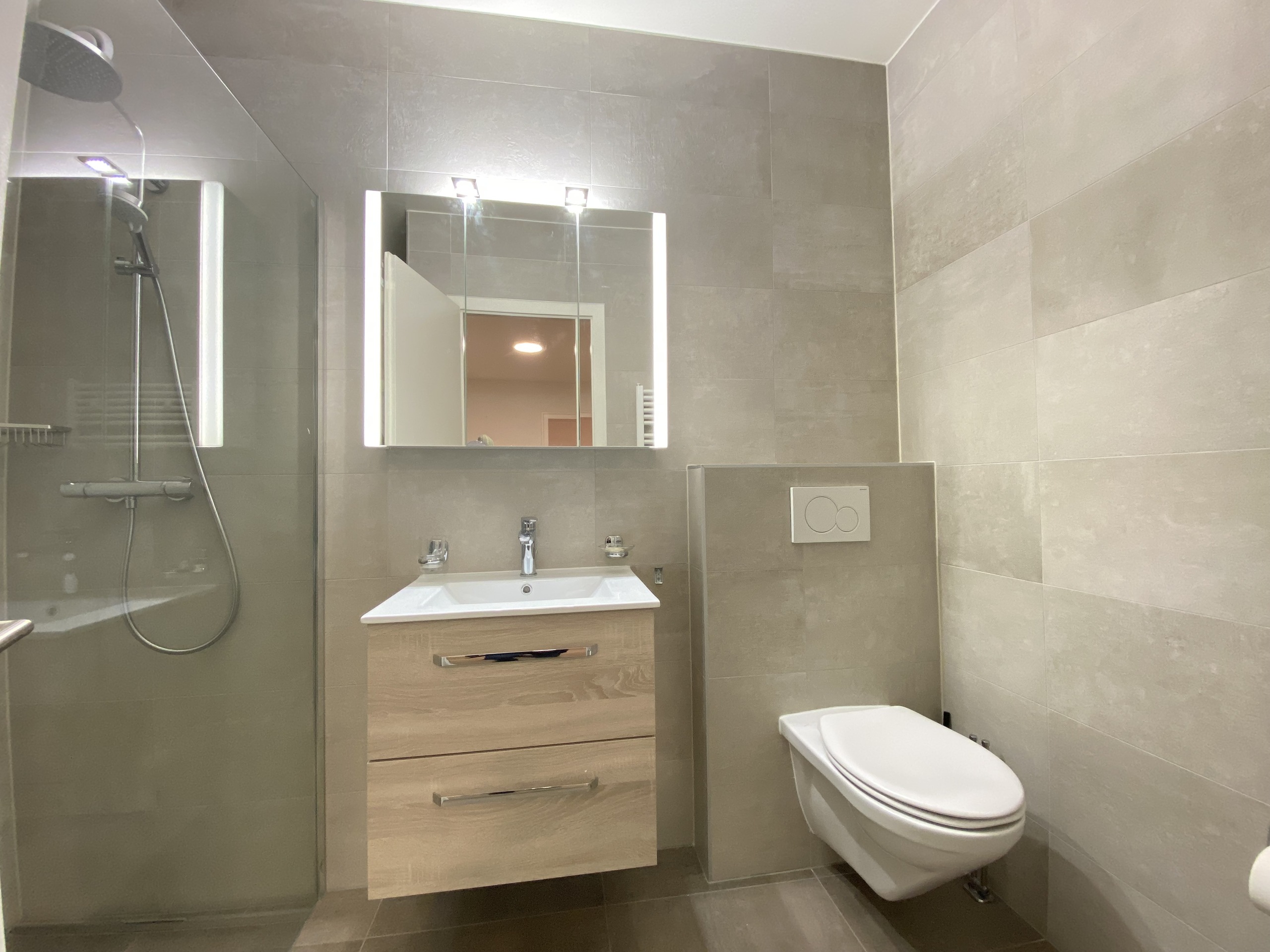 Modernes Badezimmer mit begehbarer Dusche, Waschtisch und wandhängendem WC
