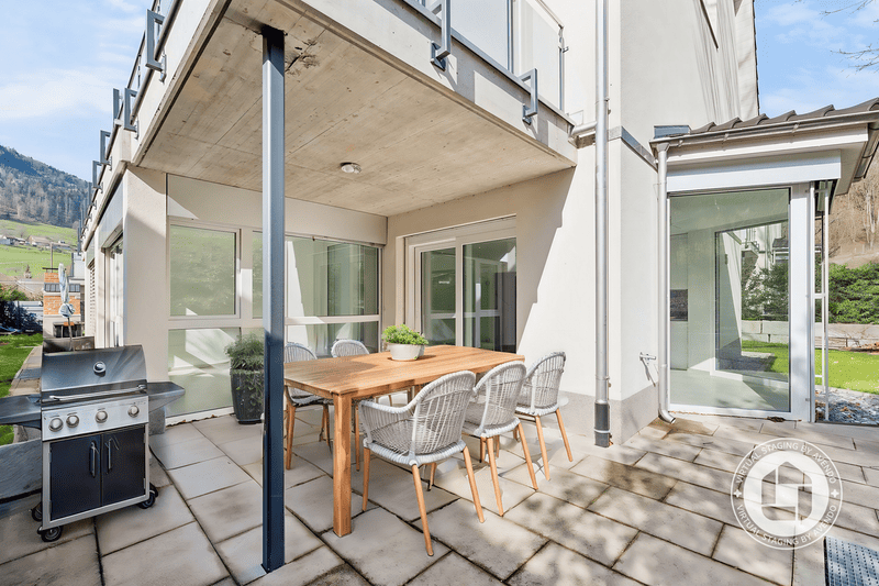 Überdachte Terrasse mit Grill und Esstisch