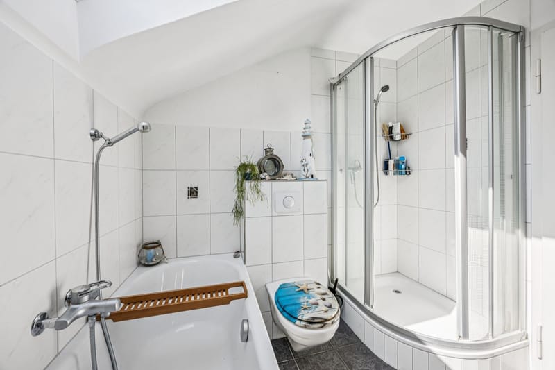 Helles Badezimmer mit Badewanne und Duschkabine