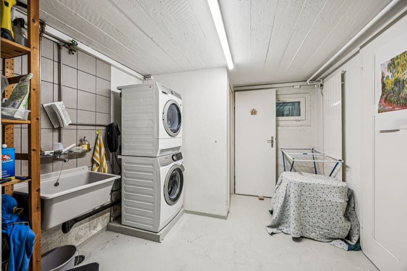 Hauswirtschaftsraum mit Waschmaschine und Ausgussbecken