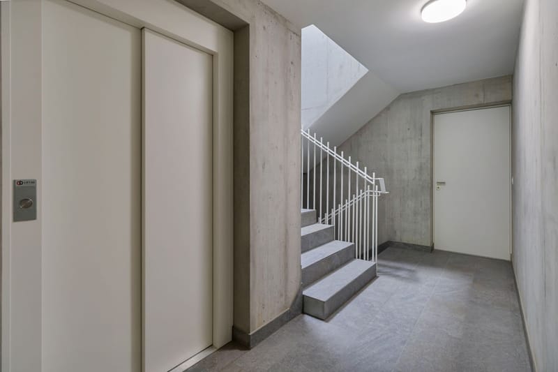 Treppenhaus mit Aufzug im Eingangsbereich