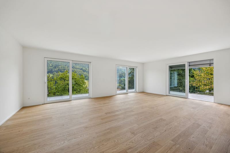 Heller leerer Wohnraum mit großen Fensterfronten