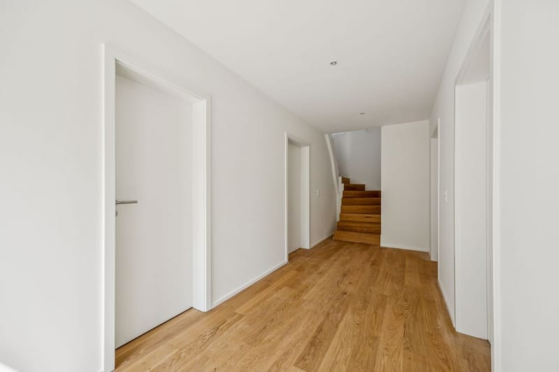 Heller Flur mit Holztreppe