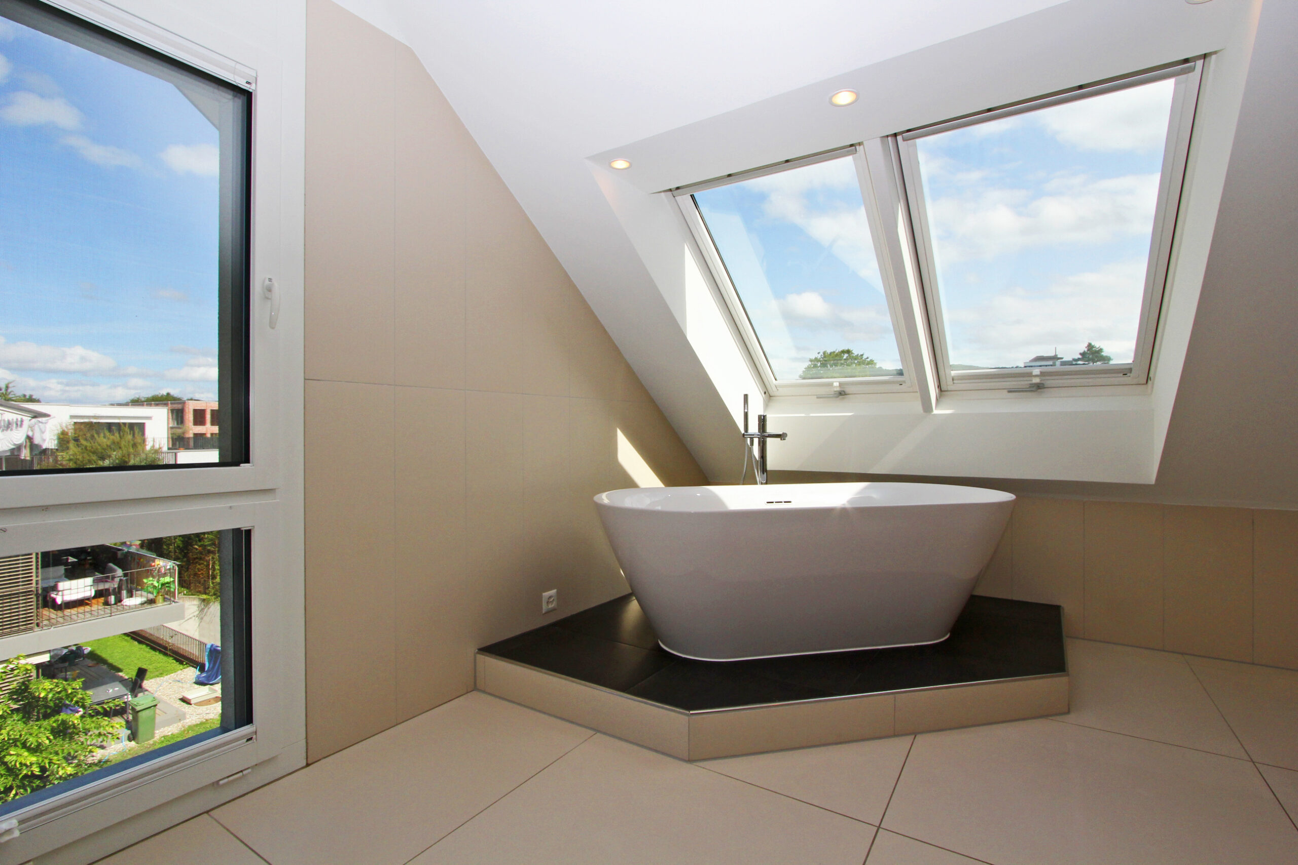 Modernes Bad mit Dachfenstern und freistehender Wanne