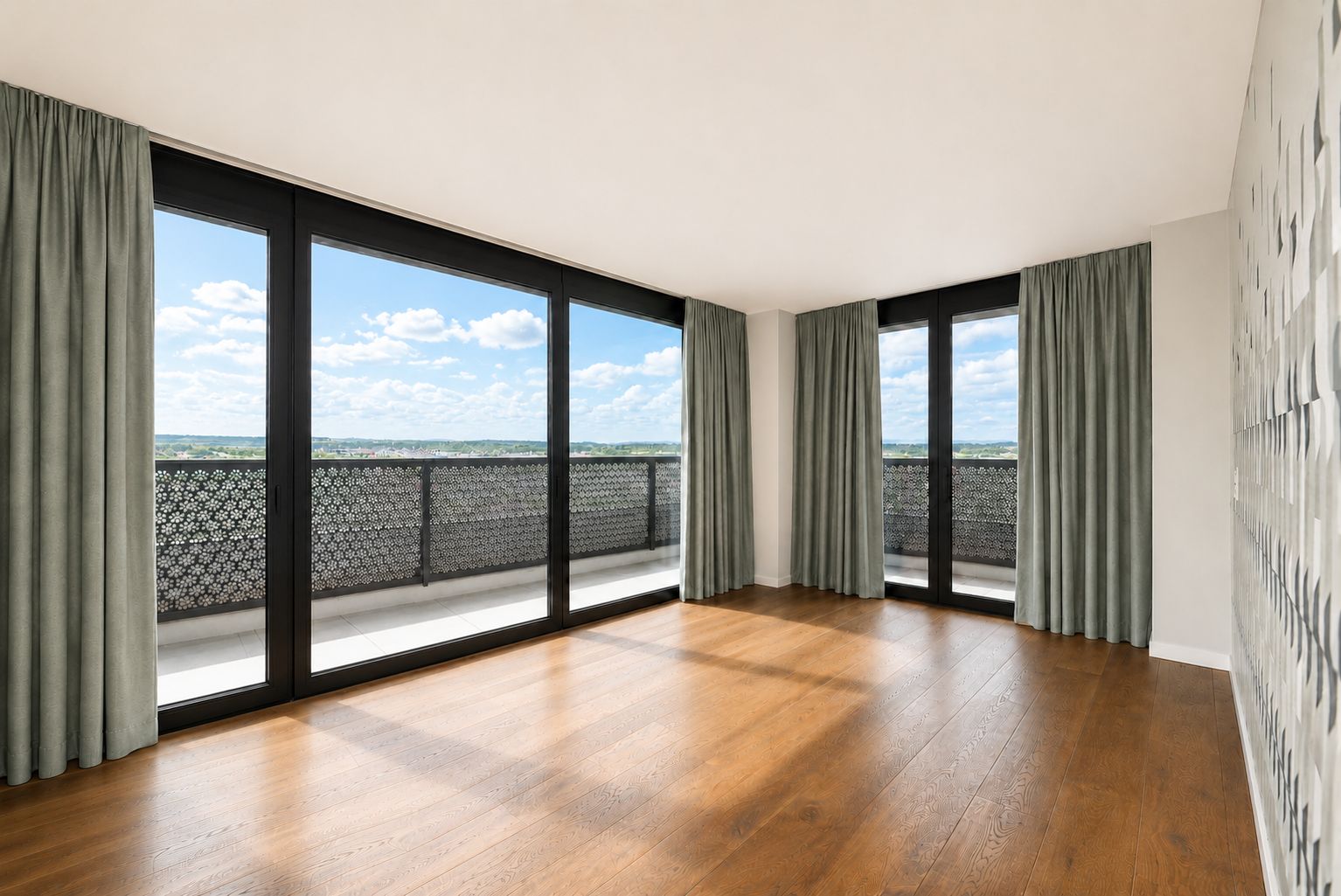 Heller leerer Raum mit großflächigen Fenstern und Balkonblick