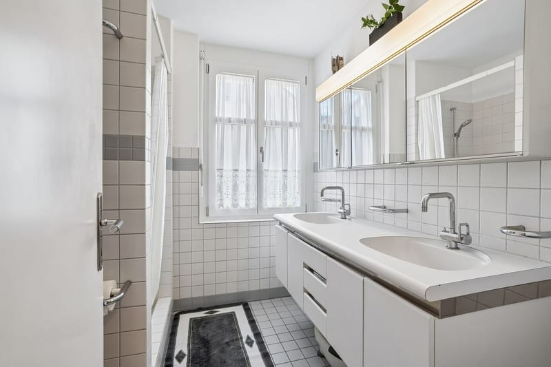 Helles Badezimmer mit Doppelwaschtisch und Fenster