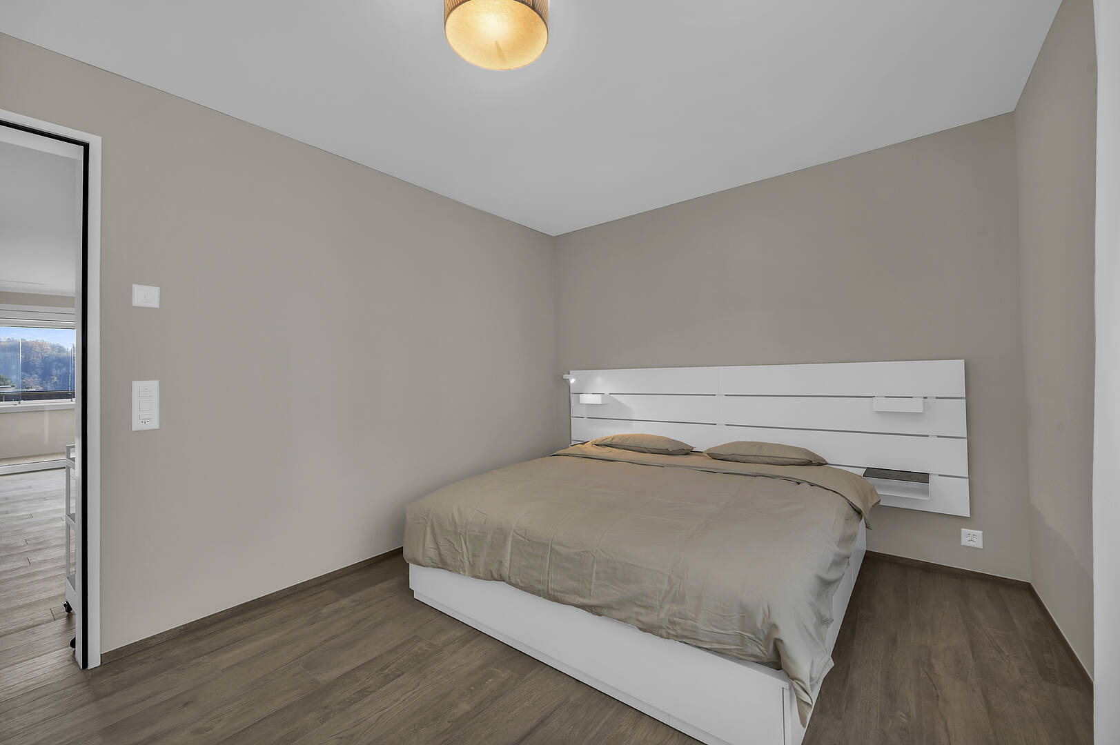 Helles Schlafzimmer mit schlichtem Bett