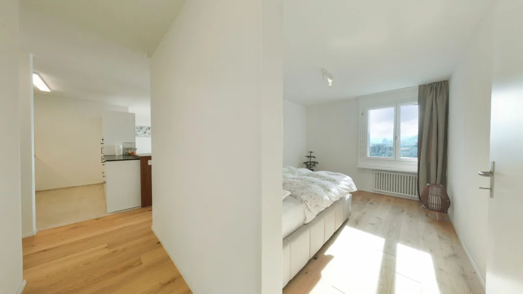 Helles Schlafzimmer mit Blick in den Flur und zum Wohnbereich