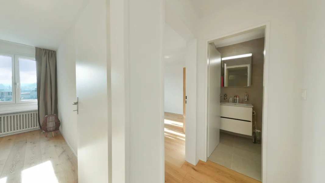 Heller Flur mit Blick in Zimmer und Bad
