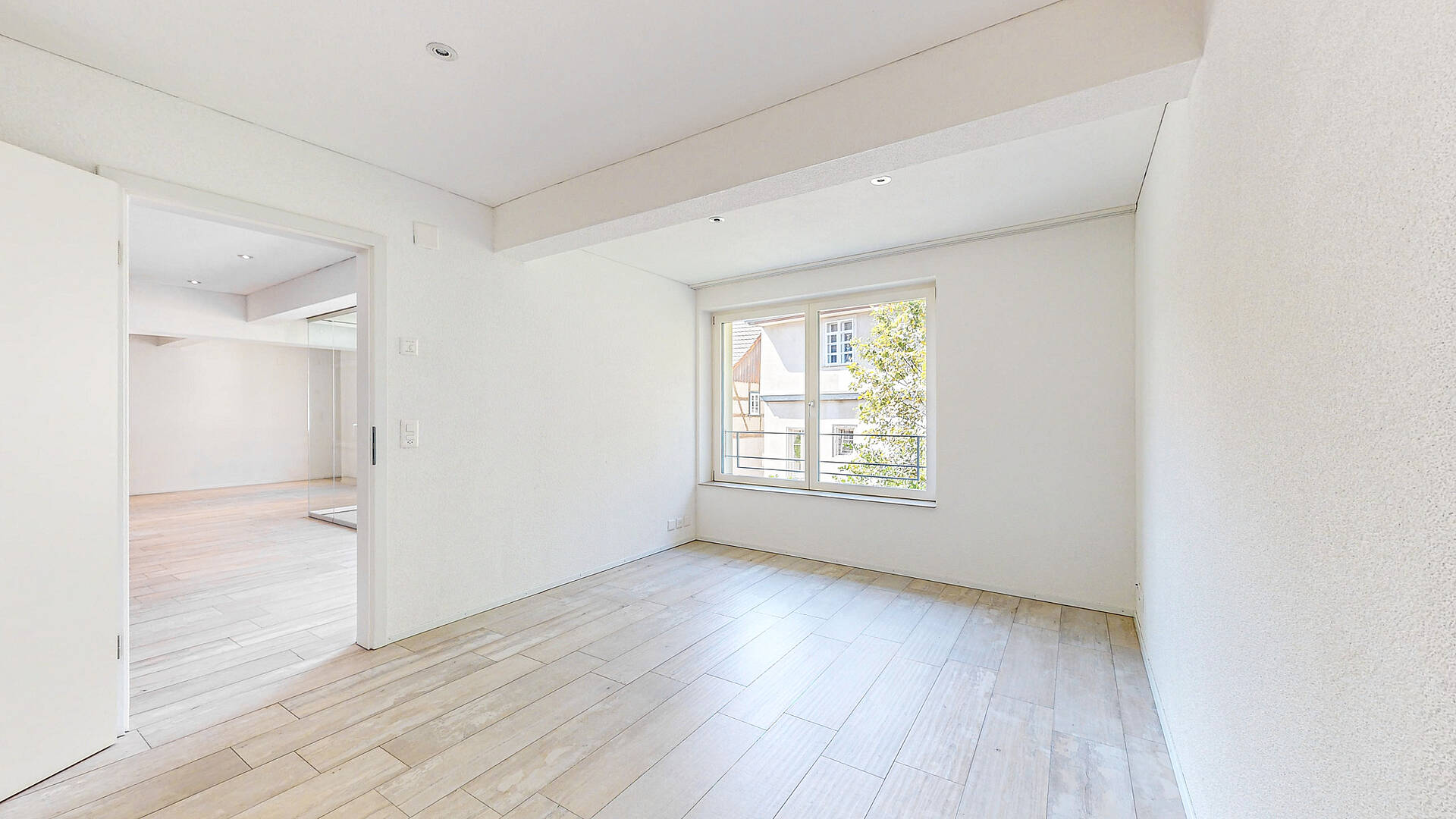 Heller leerer Raum mit Fenster und Durchgang