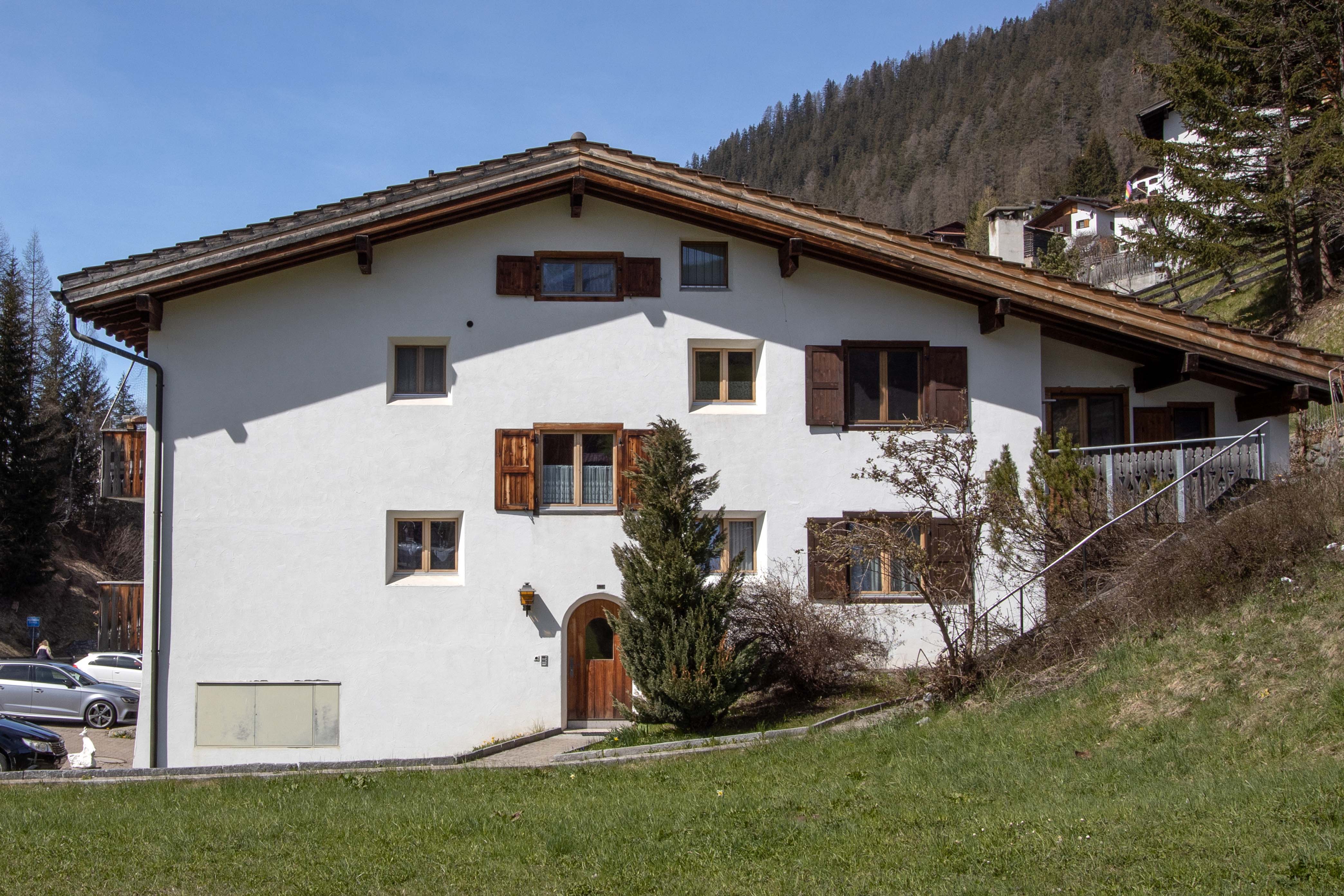 Alpenhaus mit Schrägdach und Holzläden
