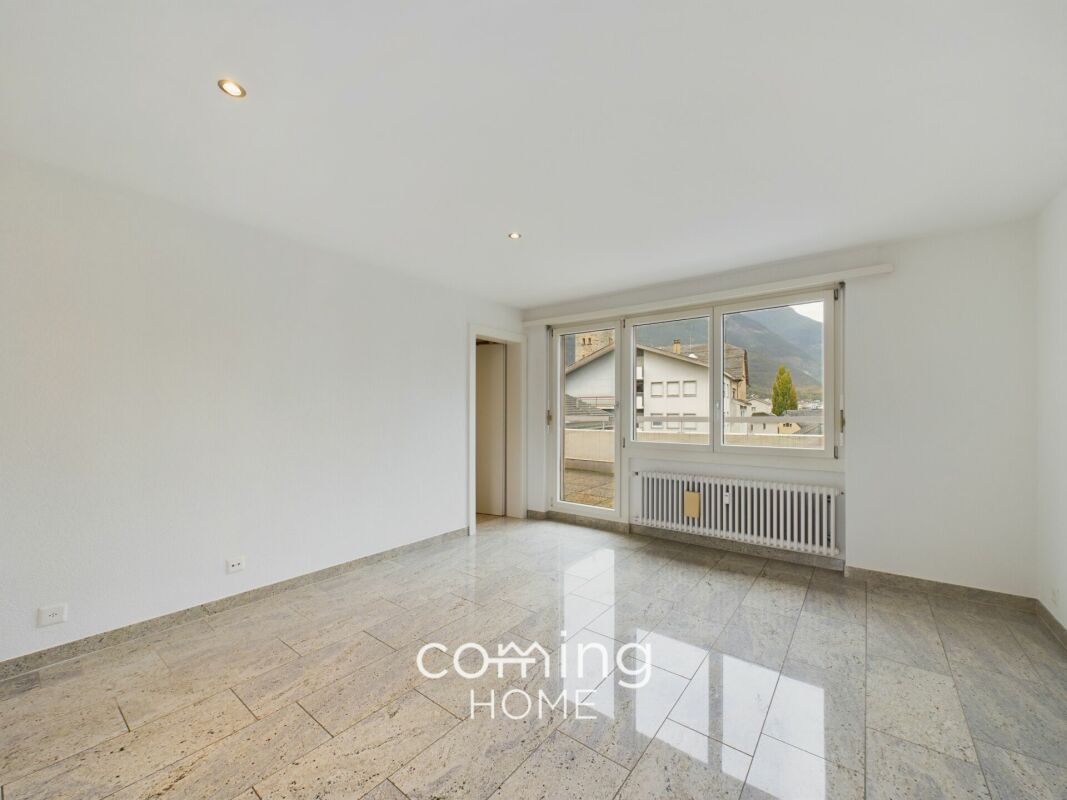 Heller leerer Wohnraum mit großem Fenster und Bergblick