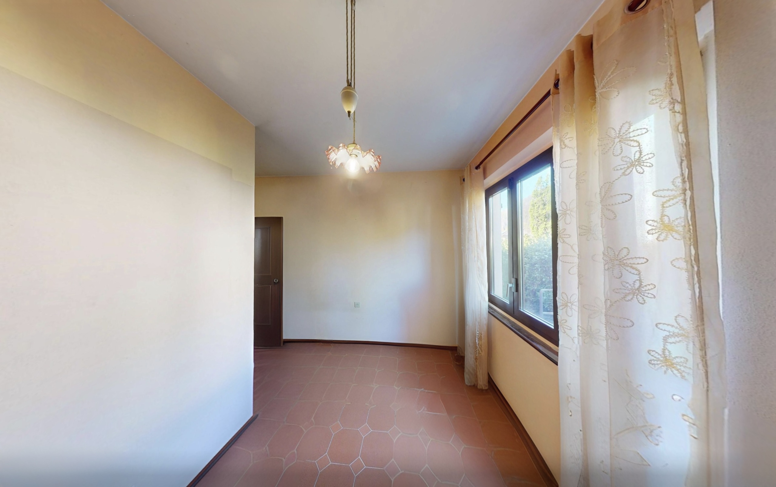 Heller Flur mit Fenster und Terrakottaboden