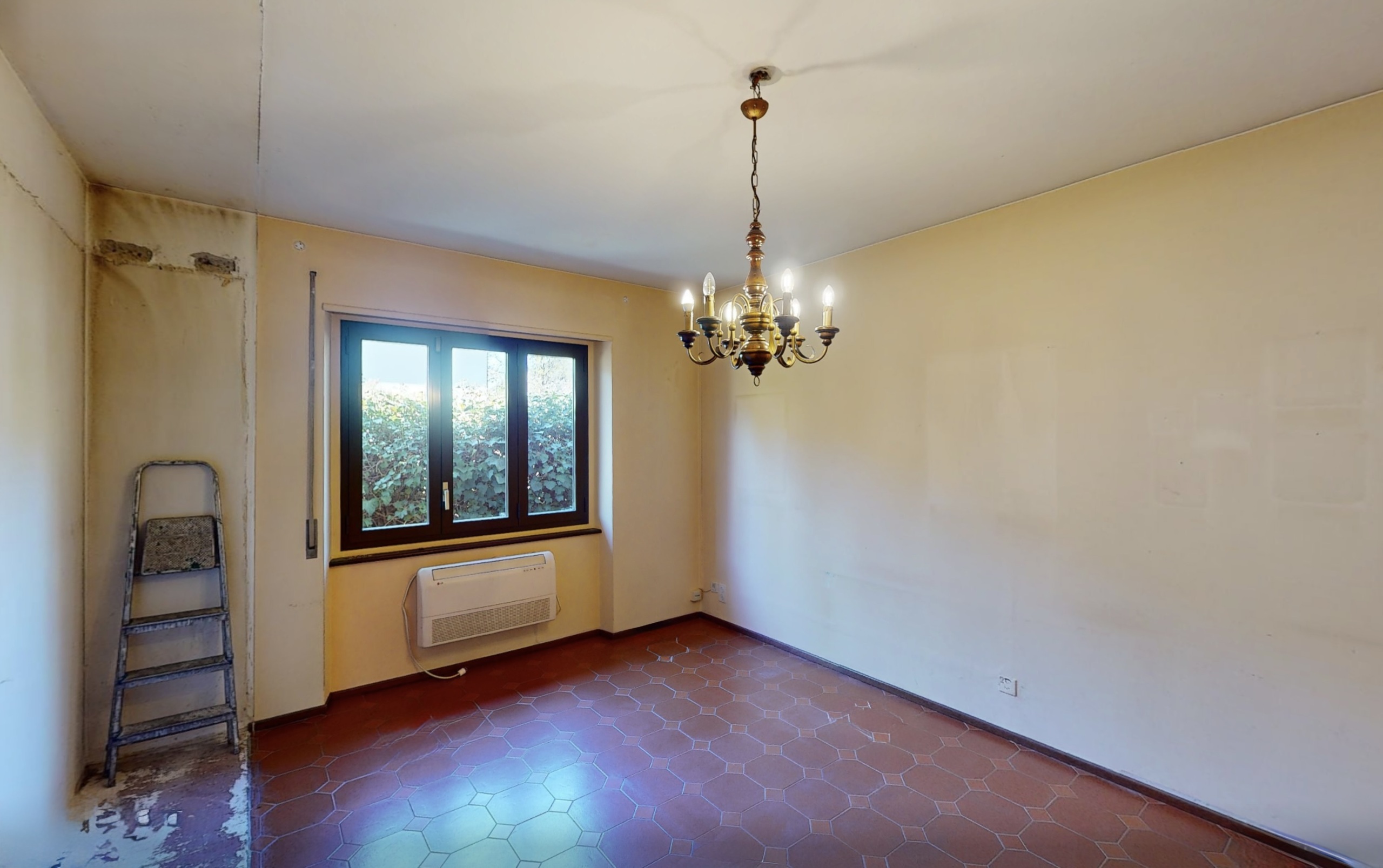 Leerer Raum mit Fliesenboden und Kronleuchter