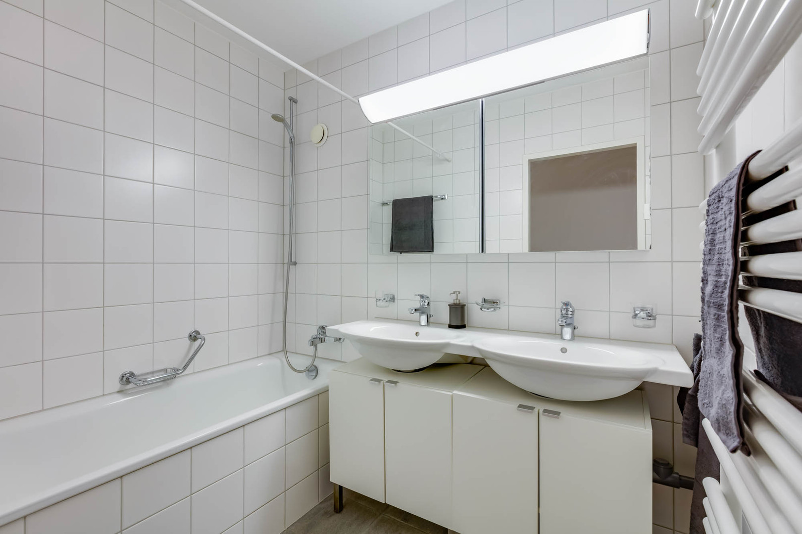 Helles Badezimmer mit Doppelwaschtisch und Badewanne